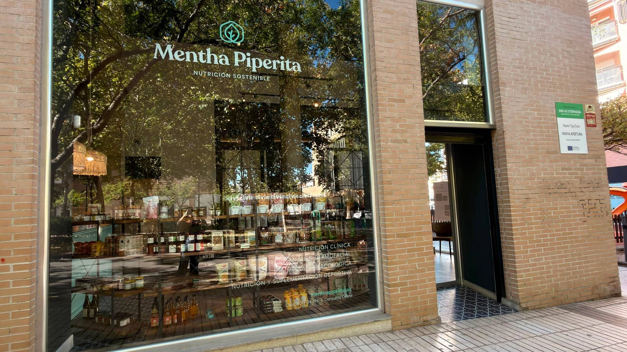 Fachada de Mentha Piperita en el Paseo Condes de Barcelona de Badajoz: escaparate de cristal con el rótulo y la puerta de entrada